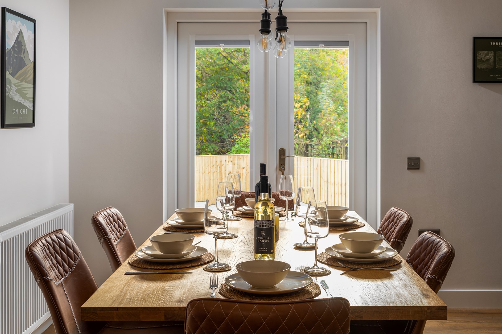 "Image of a beautifully set dinner table with plates, cutlery, and glasses, ready for a delicious meal at Coed Gelert holiday cottages in Snowdonia.